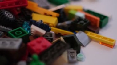 Plastik konteynırın üzerinde yatan çocuklar için renkli bir müteahhit. Pek çok renkli yapıcı parçası var. Kimlik konsepti. Beyaz arkaplanda plastik oyuncak blokları