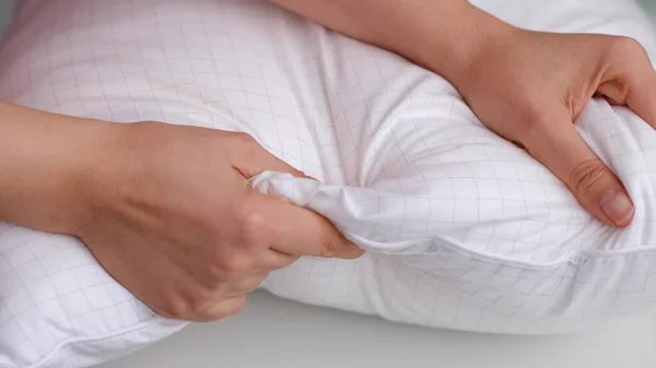 年轻女人摸柔软的白色枕头，特写。如何选择枕头，人工填充物 — 图库照片
