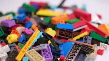 Plastik konteynırın üzerinde yatan çocuklar için renkli bir müteahhit. Pek çok renkli yapıcı parçası var. Kimlik konsepti. Beyaz arkaplanda plastik oyuncak blokları