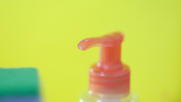 Konyhai szivacsok és egy műanyag palack természetes mosogatószeres folyékony szappannal kézi mosogatáshoz. Környezetbarát, méregmentes, zöld tisztítószer. Mosogatási koncepció. — Stock videók