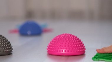 Küçük bir çocuğun bacakları ortopedik minderlerde. Yürümek ve ayağın doğru kemerini oluşturmak için parlak yüzeyler. Masaj yapboz paspası.