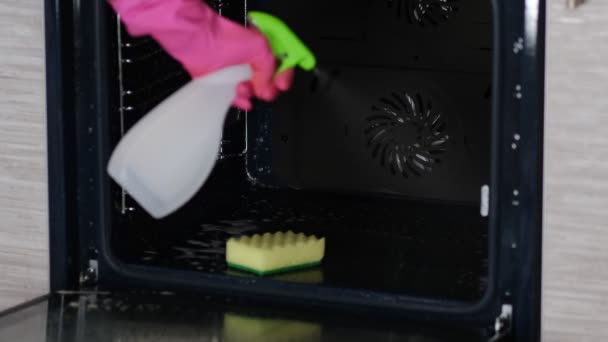 Frau wäscht den Ofen mit Schaum und Sprühflasche. Hausreinigung. — Stockvideo
