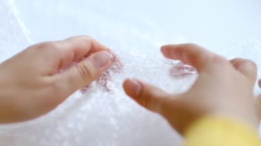 ASMR, kadın stres atmak için plastik balonlu naylona basıyor. Kabarcık paketi açılıyor