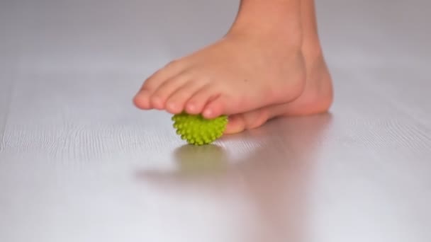 Küçük çocuk, topu miyofasiyal olarak tetikleyici noktalara masaj yapmak için kullandığını gösteriyor. Ayak masajı. Yakın çekim videosu. Yavaş çekim — Stok video