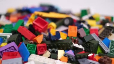 Plastik konteynırın üzerinde yatan çocuklar için renkli bir müteahhit. Pek çok renkli yapıcı parçası var. Kimlik konsepti. Beyaz arkaplanda plastik oyuncak blokları