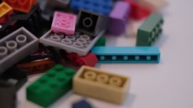 Plastik konteynırın üzerinde yatan çocuklar için renkli bir müteahhit. Pek çok renkli yapıcı parçası var. Kimlik konsepti. Beyaz arkaplanda plastik oyuncak blokları