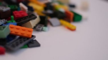 Plastik konteynırın üzerinde yatan çocuklar için renkli bir müteahhit. Pek çok renkli yapıcı parçası var. Kimlik konsepti. Beyaz arkaplanda plastik oyuncak blokları