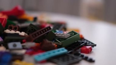 Plastik konteynırın üzerinde yatan çocuklar için renkli bir müteahhit. Pek çok renkli yapıcı parçası var. Kimlik konsepti. Beyaz arkaplanda plastik oyuncak blokları