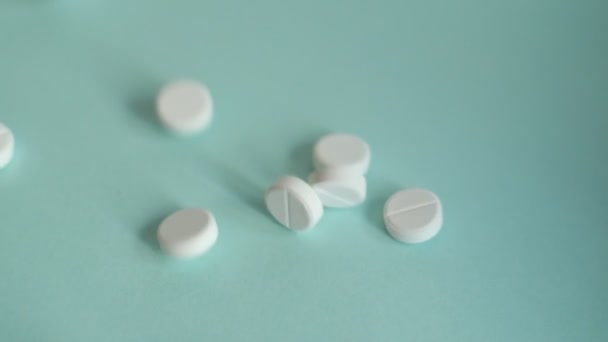 Weiße Pillen, die in Zeitlupe auf blauen Hintergrund fallen. Tabletten fliegen. medizinisches Filmmaterial, gesunder Lebensstil, Vitamine, Medikamente — Stockvideo