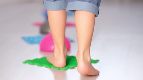Vista posterior piernas alfombra de masaje ortopédico. prevención pies planos y hallux valgus Masaje ortopédico rompecabezas alfombras para el desarrollo de los niños — Vídeos de Stock