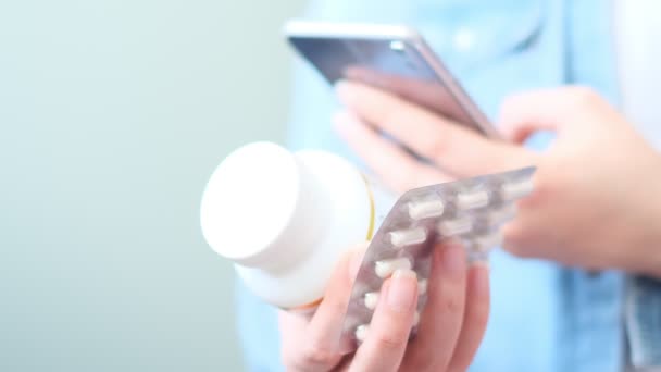 Oigenkännlig kvinna läser online medicinering instruktioner. Läkare och online konsultation. Kontraindikationer och receptbelagda tabletter. — Stockvideo