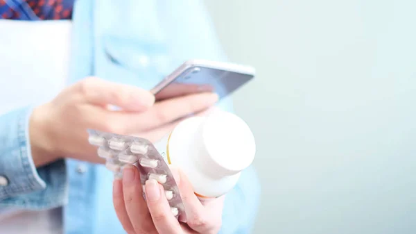 Mujer irreconocible leyendo instrucciones de medicación en línea. Doctor y consulta en línea. Contraindicaciones y píldoras recetadas. — Foto de Stock