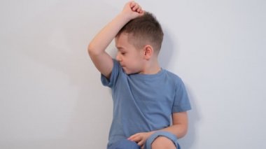 Küçük çocuk kötü kokuyor, kokluyor, ıslak koltukaltını kokluyor, ter kokuyor, hormonal değişimlerden kaynaklanan sorunlar, hareketli yüz ifadesi.