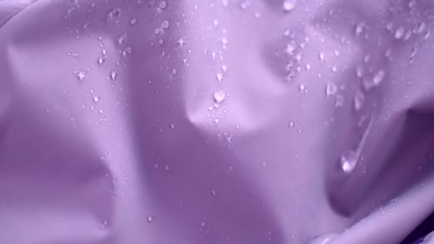 Slow Motion Shot of Water Πιτσιλιές σε αδιάβροχο ύφασμα. νερό που ξεχειλίζει από ύφασμα. Αδιάβροχο φόντο επίστρωσης με σταγόνες νερού. απαλή εστίαση, θολούρα — Αρχείο Βίντεο