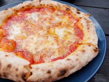 Pizza with tomato sauce baked in a pizza oven