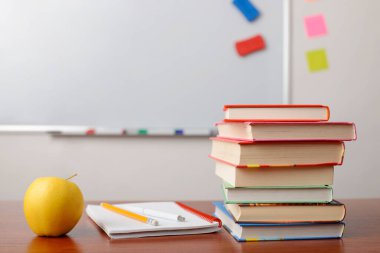 Okul malzemeleri beyaz tahtanın önündeki sınıf masasında. Kopyalama alanı ile göster