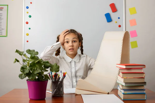 Photo of shocked pupil girl with huge to do list. Concept of many tasks, office, much work