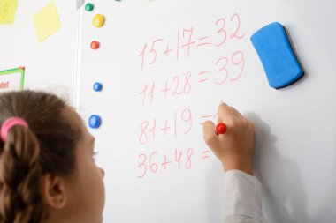 Öğrenci kız tahtaya yazı yazmakla, saymakla, matematik dersi almakla meşgul. Eğitim kavramı