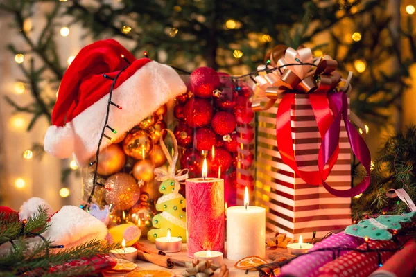 真ん中に燃えるろうそくとテーブルの上に異なるカラフルなクリスマスの装飾 クリスマスと新年を祝う準備 — ストック写真
