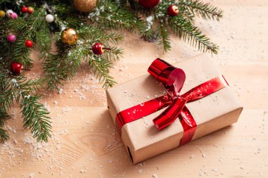 Noel hediyesi, ahşap masanın üzerindeki köknar ağacının yanında. Noel tatili