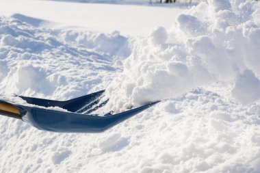 Temizlik yaparken kar atan adam. Güneşli bir kış gününde karları kürekle temizliyorum..