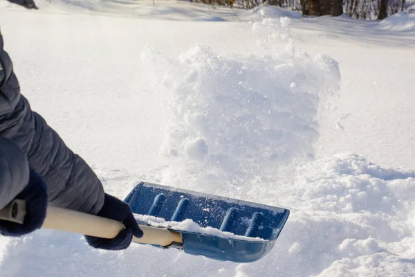 冬の晴れた朝に吹雪の後に若い男が雪をシャベル 掃除しながら雪を投げる — ストック写真