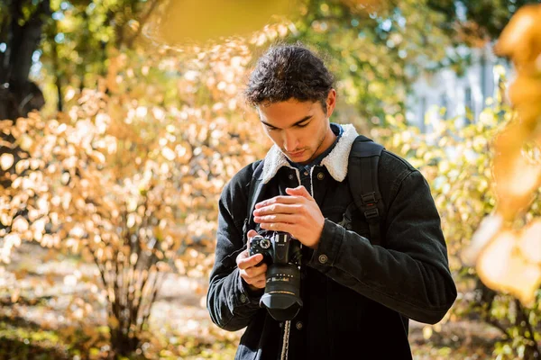 若いアマチュア写真家は 彼の現代のDslrカメラで写真をチェックします 秋の森を撮影した結果に満足 — ストック写真