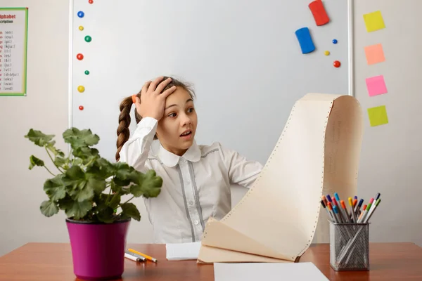 Shocked girl looking at a big list of work. Confused office worker scared of the amount of work and activities she has to do during the day