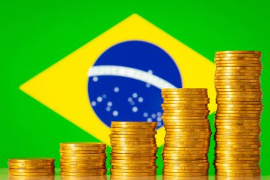 Brezilya bayrağının arka planında yığınla altın para var. Brezilya 'da ekonomik, kalkınma ve olumlu istatistiklerde artış kavramı