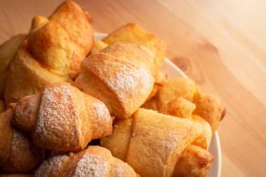 Tabakta ev yapımı fırın, ahşap masada şeker tozu ile tatlandırılmış.