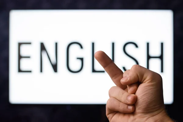 Impolite student showing middle finger to inscription ENGLISH, having no interest to study foreign language