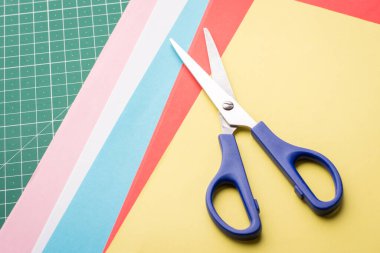 Origami yapmak için farklı renkte kağıtlar üzerinde mavi makas