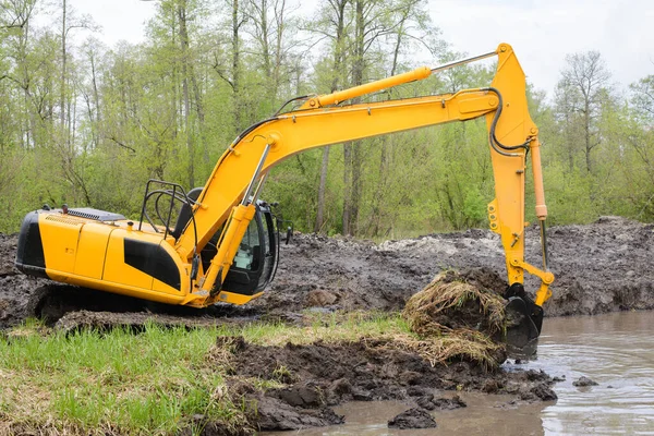 挖掘机收集了大量的土壤 用于在农村建设灌溉系统运河浇灌 — 图库照片