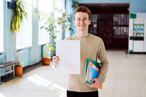 Estudante Caucasiano Feliz Mantém Papel Verificado Com Teste Final Com — Fotografia de Stock