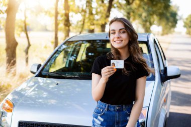 Teenader is happy to receive driving licence. Concept of buying first car