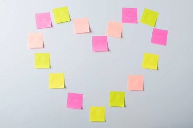 Sticky notes in a shape of a heart on white background. Symbol of love, devotion, love message