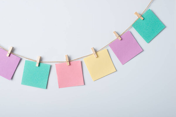 Line of colorful papers on a threat against white background