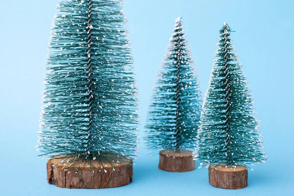 Tres Pequeños Árboles Navidad Sobre Fondo Azul Concepto Celebrar Año —  Fotos de Stock