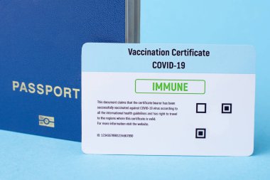 Vaccination certificate and passport on blue background. Covid-19 vaccination