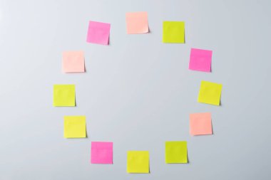 Sticky notes without any test attached on the blackboard. Colorful notes form a circle on the wall.