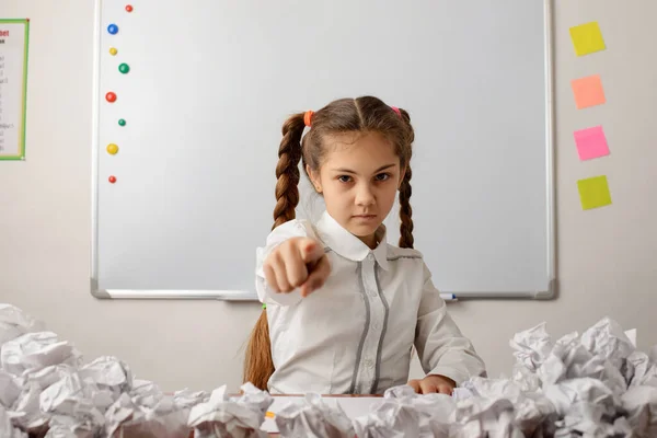 Angry School Girl Pointing Camera Sitting Desk Many Crumpled Papers — Stockfoto