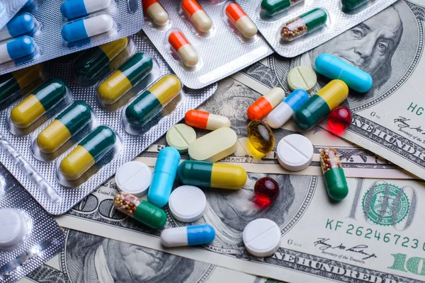 Many pills on money bills. Cost of treatment symbol