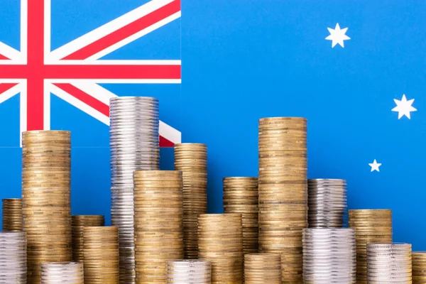 Australian flag and piles of coins. Finance and economy concept