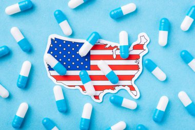 Terrible condition of heath among US citizens. Symbolic photo of many capsules on flag and map of United States