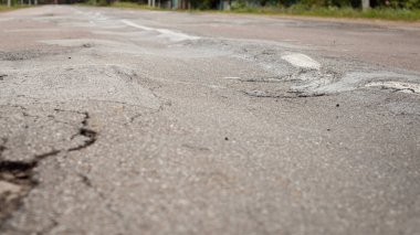 Uneven surface of asphalt road. Road in terrible condition