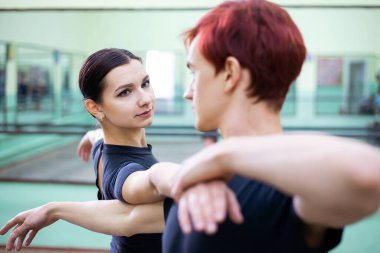 Pair of professional dancers preparing for performance on a big stage, improving their skills in the dancing hall. Pair of dancers practicing