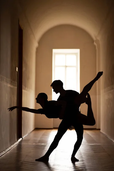Silhouette of professional ballet dancers in the corridor of the theatre. Elegant dancers practicing their performance together