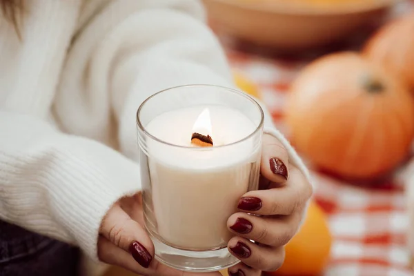 Close-up shot of a candle in hands of a girl. Beautiful autumn photo