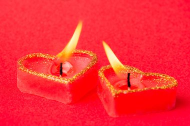 Concept of love, high feeling, passion, strong desire. Two heart candles with flames gravitating to one another