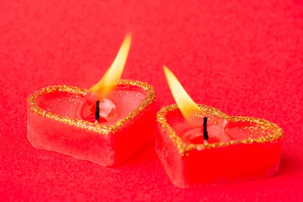 Concept of love, high feeling, passion, strong desire. Two heart candles with flames gravitating to one another